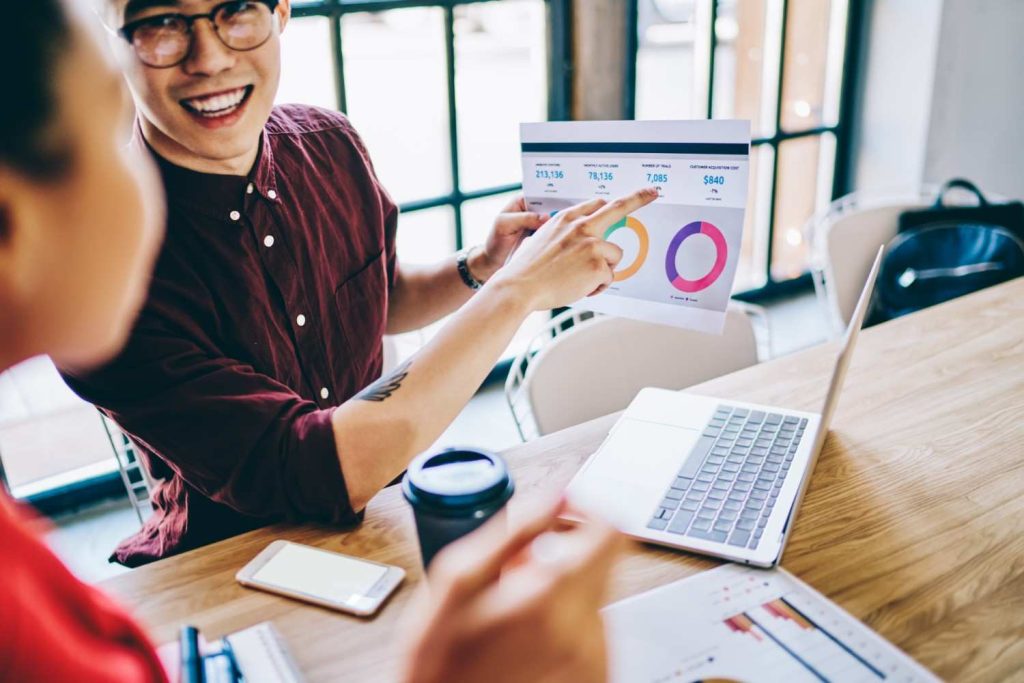 smiling-coworkers-checking-graph-in-office